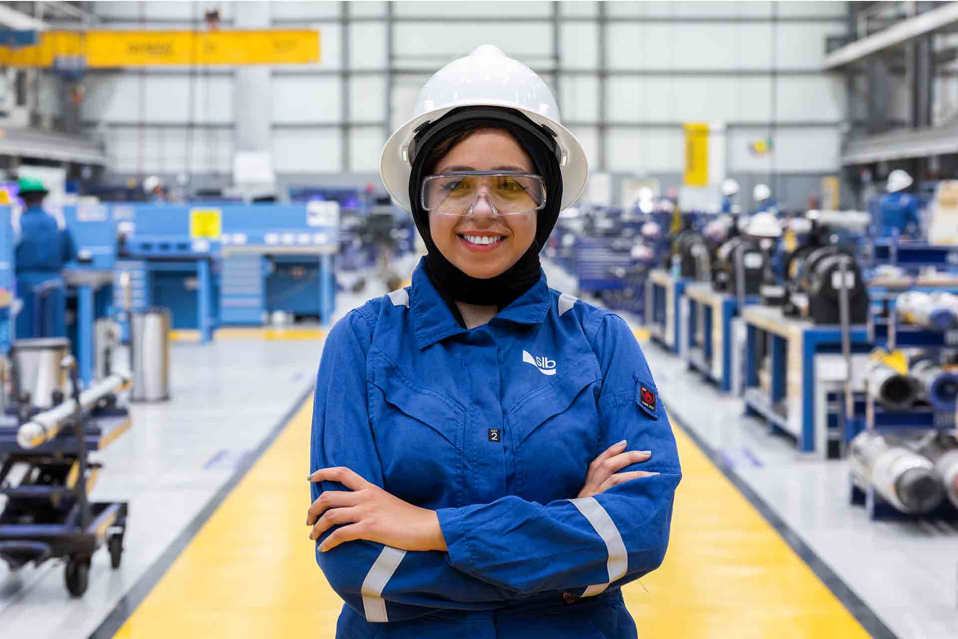 Female operator standing in a manufacturing facility walkway wearing PPE equipment
